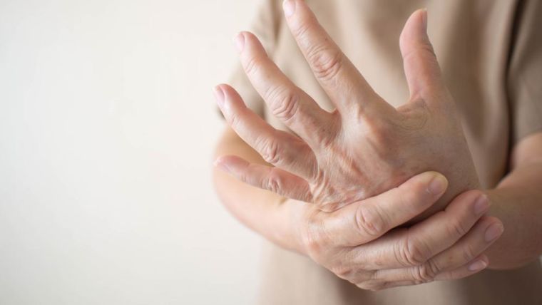A picture of someone with rheumatoid arthritis rubbing their wrist